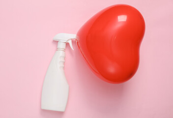 Red heart-shaped air balloon with detergent spray bottle on pink background. Valentine's Day. Creative layout