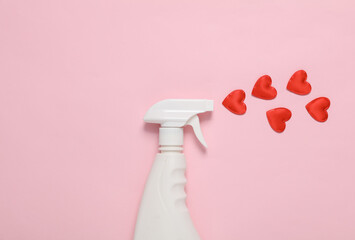 Detergent spray bottle with hearts on pink background. Valentine's Day. Creative layout. Cleaning concept