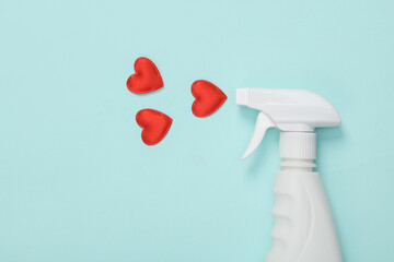 Detergent spray bottle with hearts on blue background. Valentine's Day. Creative layout. Cleaning...