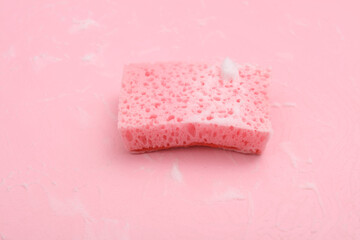 Sponge with foam on a pink background. Cleaning concept