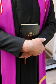Close-up of Priest Holding Bible