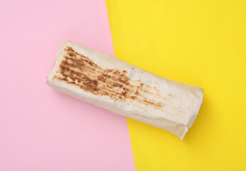 Shawarma on a yellow-pink background. Top view