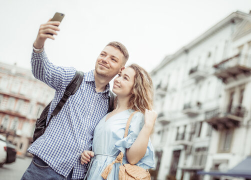 Young couple in love makes selfie on a smartphone in the city. Spending time together concept