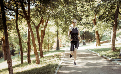 Fototapeta premium Young blonde woman jogging in the park