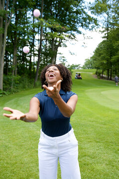 Woman Juggling Golf Balls on Golf Course