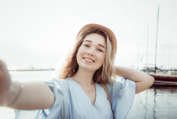 Selfie portrait of a young cute woman on the background of yacht club