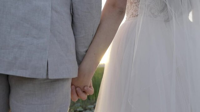 A couple holding hands while sunbeams between their hands. Shot in4k60 fps. Email willneatheryyahoo.com to purchase entire wedding event at wholesale price.