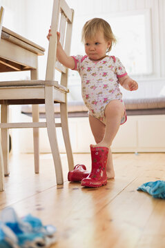 Girl Putting on Rubber Boots