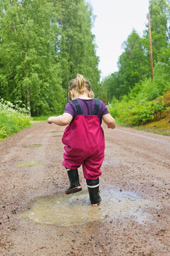 Young Girl Playing in Puddle, Sweden