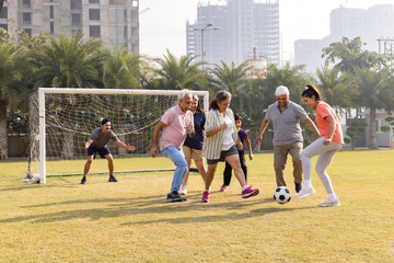 Obraz premium Happy multi generation family playing football together in the football ground.