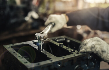 Auto mechanic working on car engine in mechanics garage. Repair service. Car care maintenance and servicing, Close-up hand technician auto mechanic using the wrench to repairing change spare.