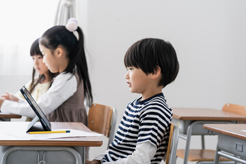 教室でタブレットPCを見る日本人小学生 © arc image gallery