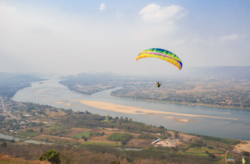 Paragliding in the sky. Paraglider  flying over Landscape from Beautiful View Mekong River at Wat...