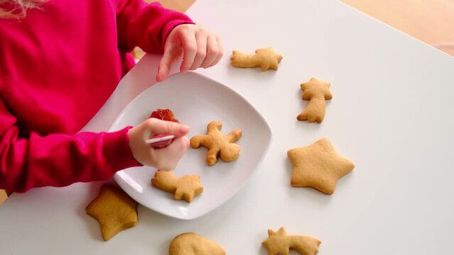 Childrens hands painting gingerbread cookies. Cooking