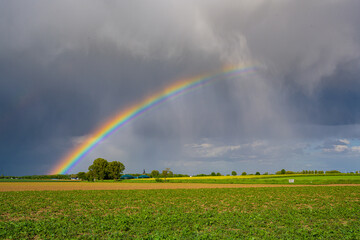 Regenbogen mit Regen und tiefen Wolken