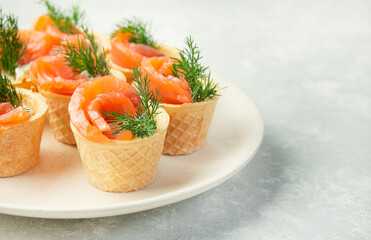 Snack with red fish on a plate on a light background. Side view. Copy space.