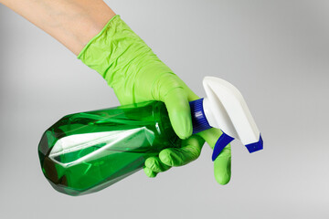 Woman's hand with a pressure sprayer on gray background.