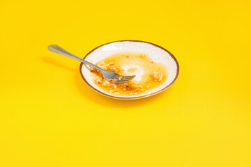 dirty plate with honey and pie crumbs on yellow background