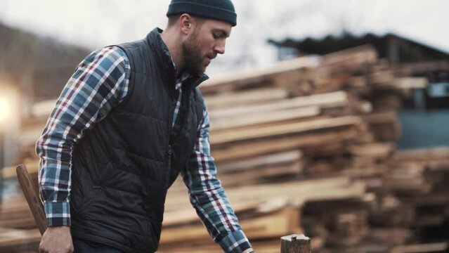 close-up of a working man chopping firewood with an ax