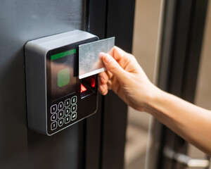 A woman opens the door with a plastic card. Modern keyless entry lock. 
