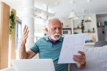 Man worried about his monthly payments. Serious senior man holding letter feels interested read business news, got invitation, learns bank statement information. Postal correspondence concept