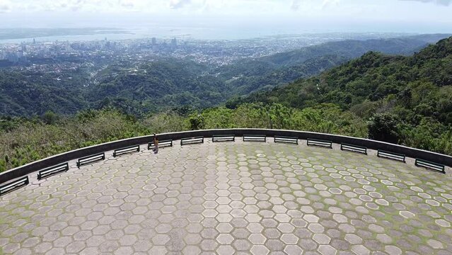 Drone shot of a beautiful place overlooking the city. This is a famous location to get a 180 degrees view of Cebu City, Philippines. The drone is moving forward a cliff.