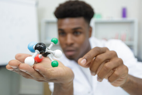 young man works on a model of molecule