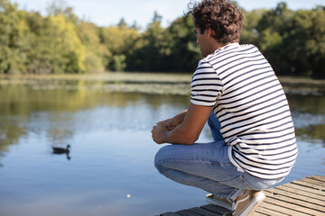 man stands on the sand lake coast