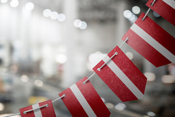 A garland of Latvia national flags on an abstract blurred background
