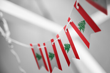 Obraz premium A garland of Lebanon national flags on an abstract blurred background
