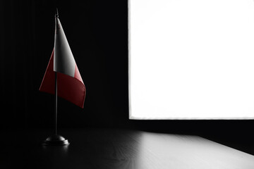 Small national flag of the Malta on a black background