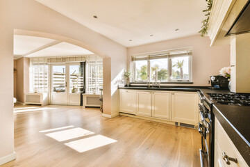a kitchen with wood flooring and white cabinets in the middle of the room there is an open door...