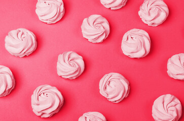 colorful marshmallows on magenta background. Color of year 2023. Viva magenta. Color sweet homemade zephyr