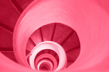 Old stairs in spiral staircase toned in Color of year 2023. Viva magenta.