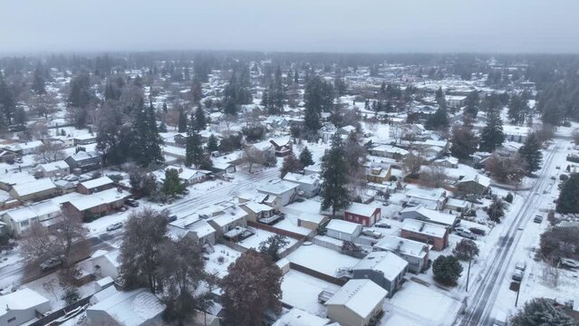 Establishing aerial view of snow covering a wide swathe of houses.