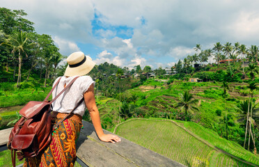 Young girl with hat  looking the ricefields. Rice terraces famous place Tegallalang near Ubud. The island Bali in indonesia in southeastasia.