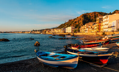 boats in a dock in  morning sunrise sea gulf with a embankment of a town on a background