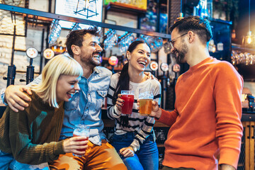 Smiling young friends drinking craft beer in pub - obrazy, fototapety, plakaty