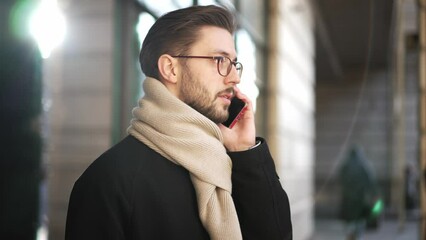 Confident young business man talking on smartphone. Smartphones have become a lifeline for businesspeople on the big city. European businessman talking on the phone walking down the street to work. - Powered by Adobe
