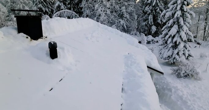 Aerial view low over snow covered solar panels on a house roof - reverse, drone shot