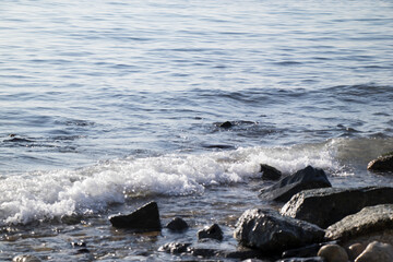 The waves crashing on the rocky shore and their foam, the vast sea and the deep blue sky
