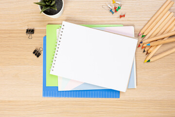 Notebook mockup with school stationery on a wooden table. back to school concept. Blank notepad...