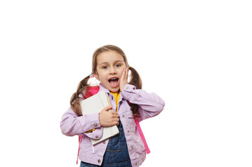 Surprised Caucasian little girl with two ponytails, a first grade student with wow emotions, expressing surprise and positive emotion, posing with open mouth, looking at camera, on white background