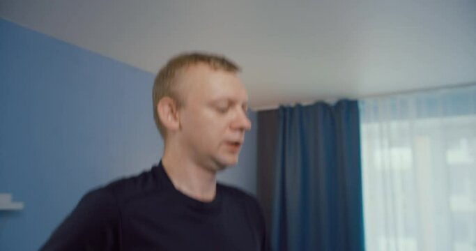 Man do exercise at home running on treadmill. Headshot footage