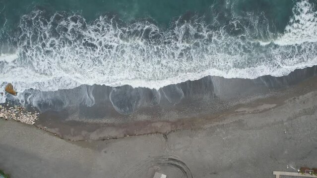 Aerial Push out shot of a sandy beach near the road in Candado, M&aacute;laga, Spain.
