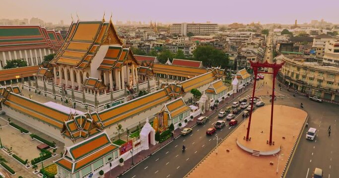 An aerial view of Red Giant Swing and Suthat Thepwararam Temple at sunset scene, The most famous tourist attraction in Bangkok, Thailand.