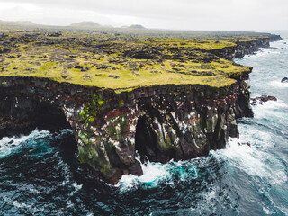 Spectacular black volcanic rocky ocean coast with cave arch and towers - Iceland