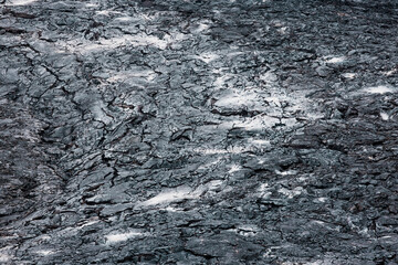 Close up cooled black volcanic rock, with ash grey patches on the surface - Iceland