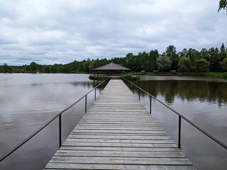Naklejka premium Wooden gazebo in the pier on the river with water in the background.