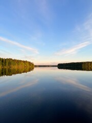 Forest trees silhouette reflection on the quiet lake surface, very peaceful, no people, lake reflection background